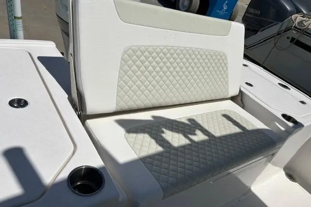 Slide: The Image of Caymas 26 HB 2021 boat seat with diamond-pattern upholstery and cup holders. - 9