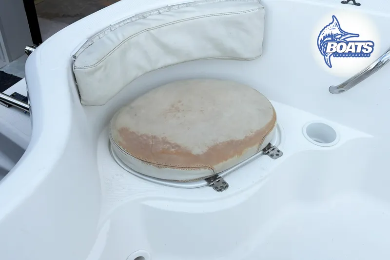 Slide: The Image of 2004 Wellcraft 180 Fisherman boat seat with logo, featuring white and beige upholstery. - 13