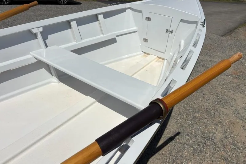 Slide: The Image of White 2006 Homebuilt V-HULL boat with wooden oars on gravel surface. - 6