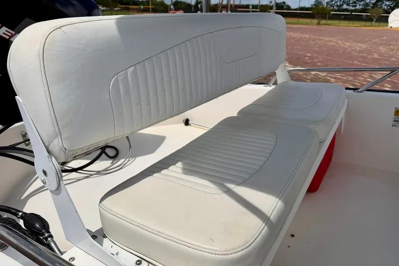 Slide: The Image of White seating on a 2002 Boston Whaler 130 Sport boat, showcasing clean upholstery. - 10