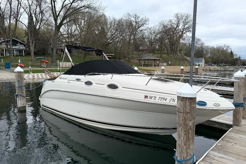 The Image of 2004 Sea Ray 240 Sundancer docked at a serene lakeside marina. - 1