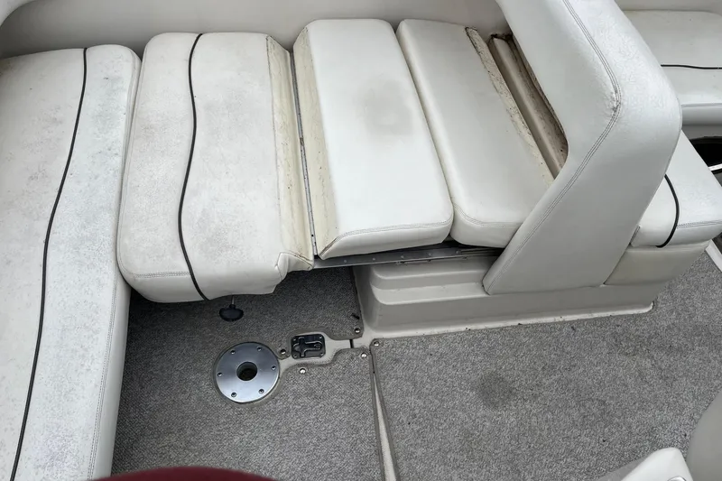 Slide: The Image of 2004 Sea Ray 240 Sundancer interior with white seating and carpeted floor. - 10
