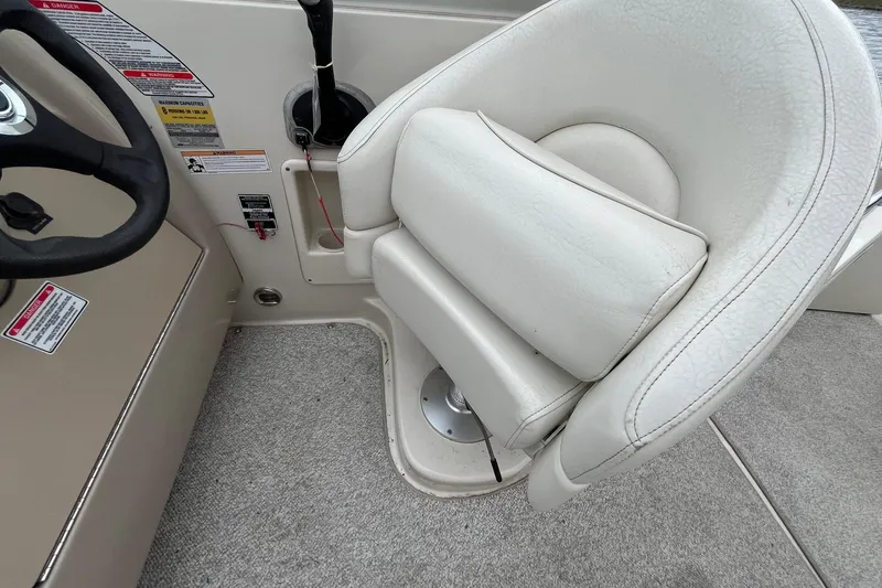 Slide: The Image of 2004 Sea Ray 240 Sundancer helm with white captain's chair and steering wheel. - 15