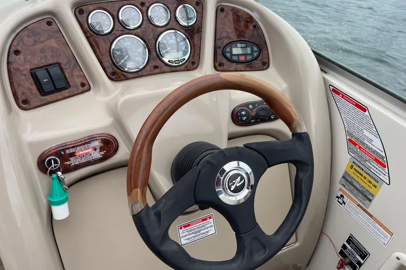 Slide: The Image of Dashboard of a 2004 Sea Ray 240 Sundancer boat with steering wheel and gauges. - 16