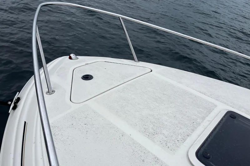 Slide: The Image of Bow of 2004 Sea Ray 240 Sundancer on water, featuring stainless steel railings. - 19