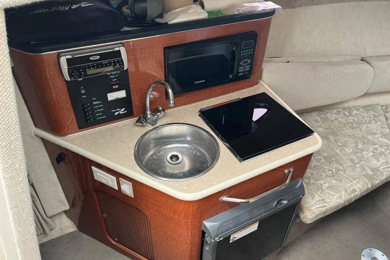 Slide: The Image of Compact galley in 2004 Sea Ray 240 Sundancer with sink, microwave, and stove. - 21