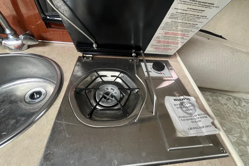 Slide: The Image of 2004 Sea Ray 240 Sundancer boat kitchen with stove and sink. - 23