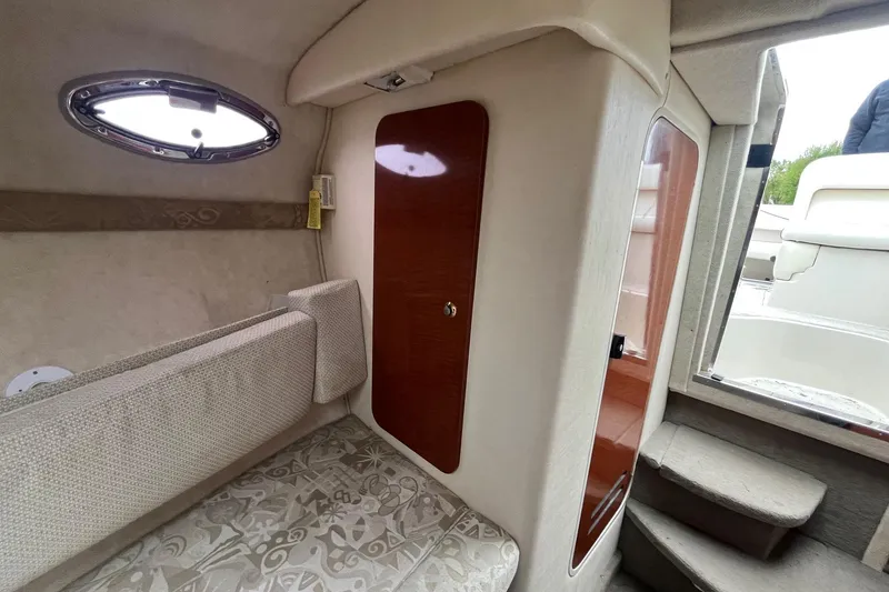 Slide: The Image of Interior of 2004 Sea Ray 240 Sundancer boat, featuring seating and cabin door. - 27