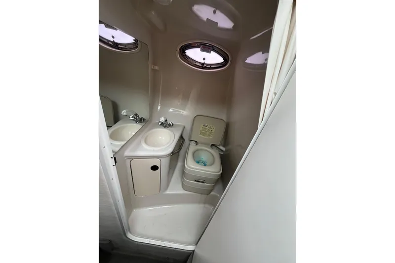 Slide: The Image of Compact bathroom in 2004 Sea Ray 240 Sundancer boat with sink and toilet. - 29