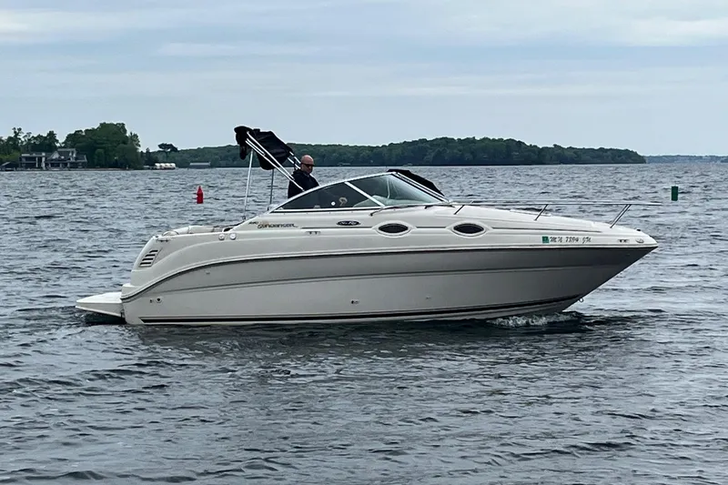 Slide: The Image of 2004 Sea Ray 240 Sundancer cruising on a calm lake with scenic shoreline. - 3
