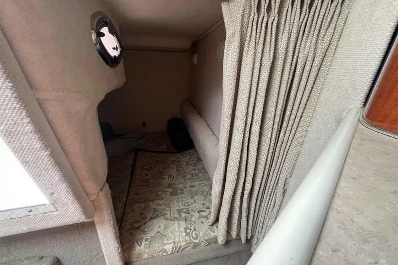 Slide: The Image of Interior cabin of 2004 Sea Ray 240 Sundancer with patterned flooring and curtain. - 31