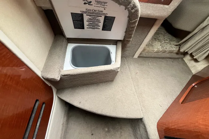 Slide: The Image of Interior of a 2004 Sea Ray 240 Sundancer boat with carpeted flooring. - 33