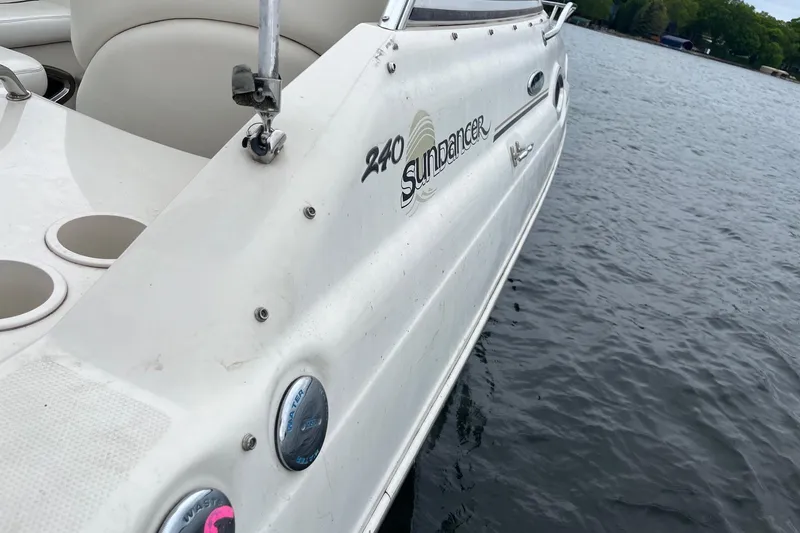 Slide: The Image of 2004 Sea Ray 240 Sundancer boat on water, showcasing side view and branding. - 36