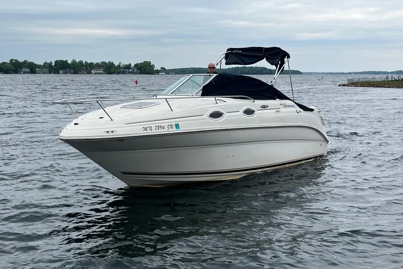Slide: The Image of 2004 Sea Ray 240 Sundancer boat on a calm lake under cloudy skies. - 5