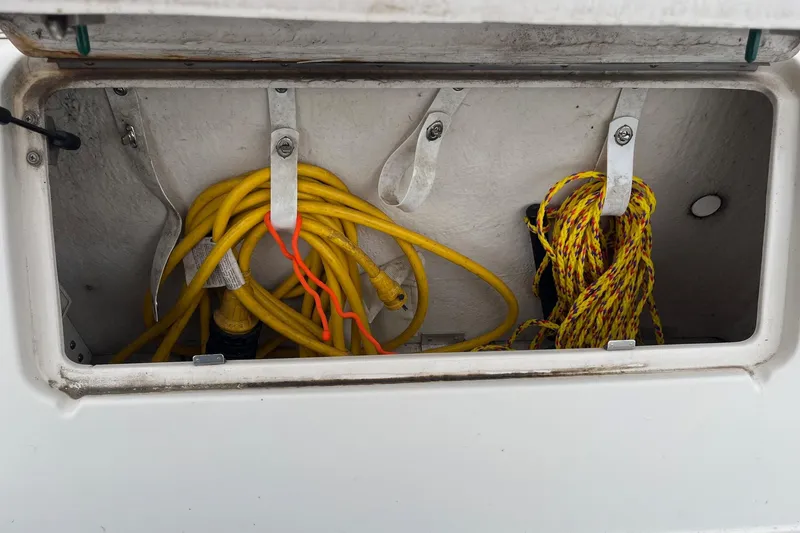 Slide: The Image of Storage compartment with yellow and red ropes on a 2004 Sea Ray 240 Sundancer boat. - 7