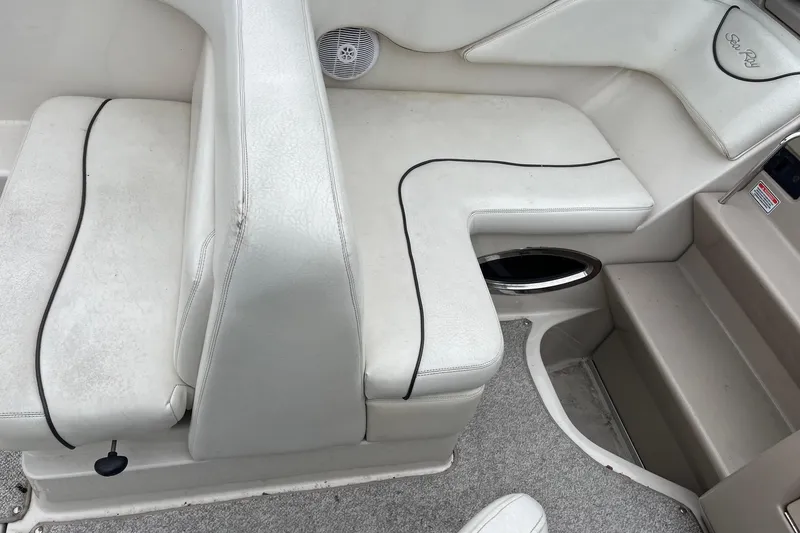 Slide: The Image of Interior seating of a 2004 Sea Ray 240 Sundancer boat, featuring white upholstery. - 9