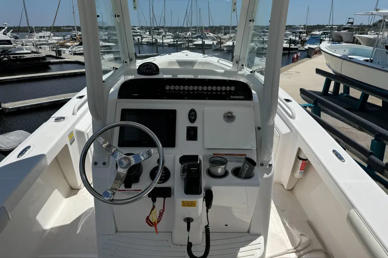 Slide: The Image of 2017 Everglades 243 Center Console boat dashboard at marina with steering wheel and controls. - 9