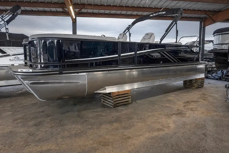 The Image of 2026 SunCatcher Fusion 324SL pontoon boat displayed in a covered showroom. - 0
