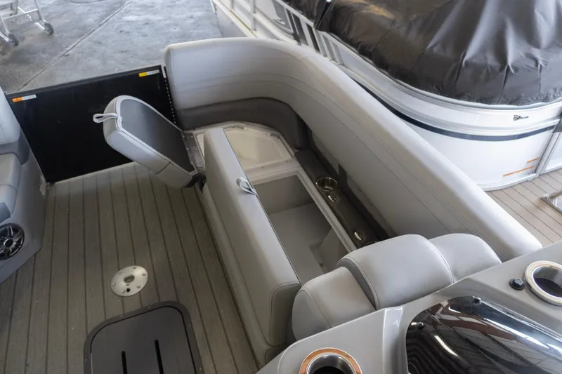 Slide: The Image of 2026 SunCatcher Fusion 324SL boat interior with gray seating and storage compartments. - 11
