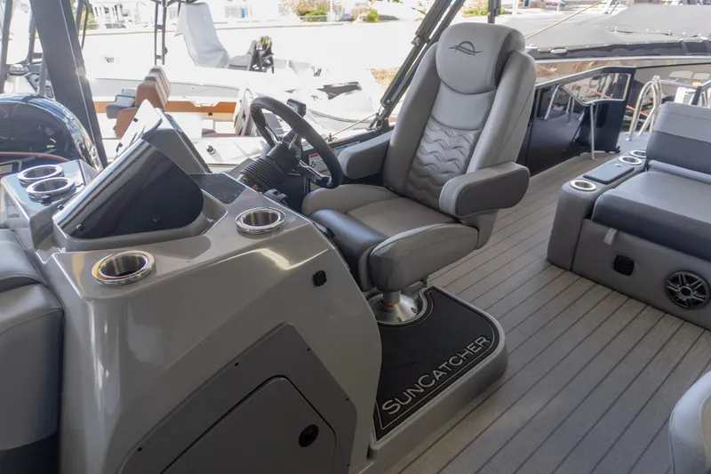 Slide: The Image of Captain's chair and helm of 2026 SunCatcher Fusion 324SL boat, featuring sleek design and controls. - 17