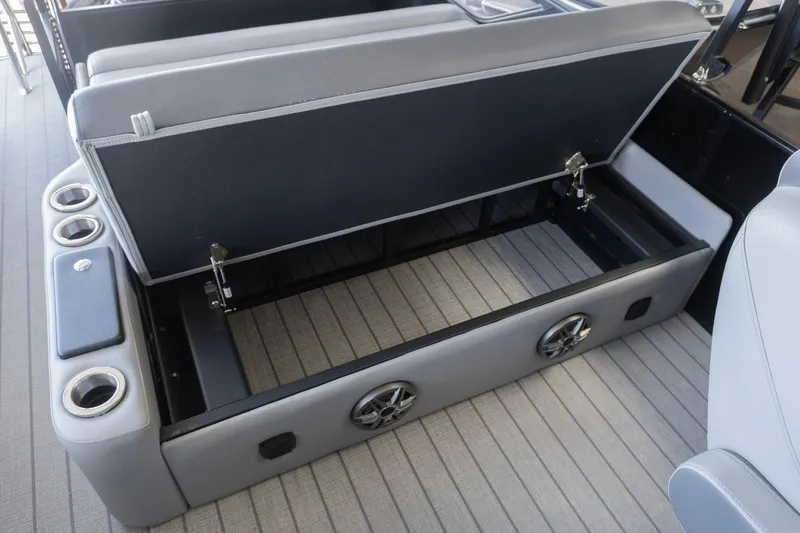 Slide: The Image of Open storage compartment in SunCatcher Fusion 324SL boat, featuring cup holders and speakers, 2026 model. - 18