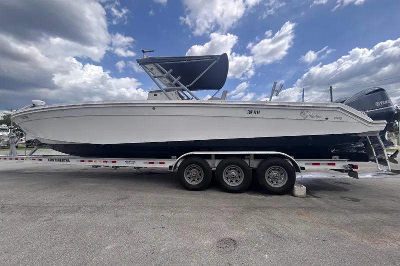 Slide: The Image of A 2011 Jefferson Marlargo FS35 boat on a trailer under a partly cloudy sky. - 10