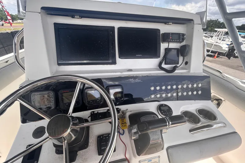 Slide: The Image of Control panel of a 2011 Jefferson Marlargo FS35 boat with steering wheel and navigation screens. - 25