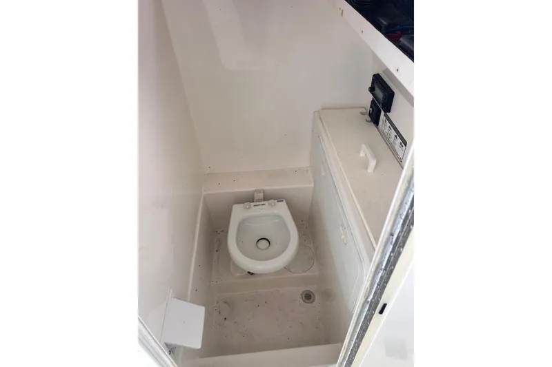 Slide: The Image of Compact bathroom in a 2011 Jefferson Marlargo FS35 boat, featuring a toilet and storage cabinet. - 31