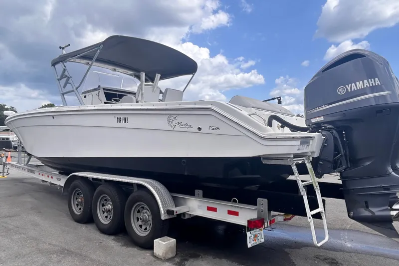 Slide: The Image of White 2011 Jefferson Marlargo FS35 boat on trailer with Yamaha engine under cloudy sky. - 9