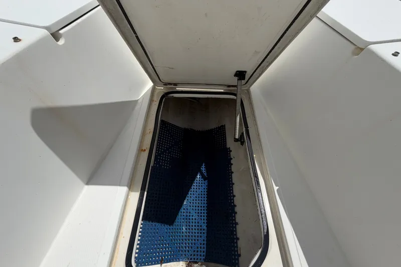 Slide: The Image of Open storage compartment on 2011 Jefferson Marlago FS35 boat, featuring blue mat inside. - 56
