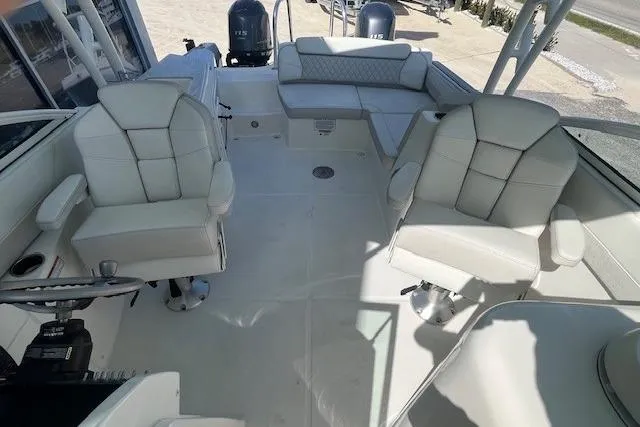 Slide: The Image of 2024 World Cat 230 SD boat interior with white seating and dual engines. - 5
