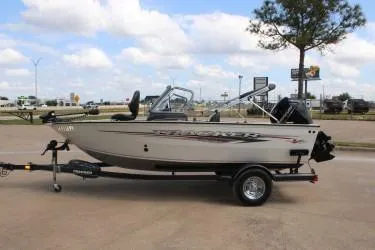Slide: The Image of 2020 Tracker Pro Guide V-165 WT boat on trailer, parked outdoors under a cloudy sky. - 7