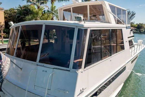 Slide: The Image of 1993 Viking Convertible yacht docked by palm trees on a sunny day. - 12