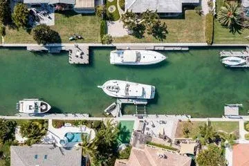 Slide: The Image of Aerial view of a 1993 Viking Convertible yacht docked in a residential canal. - 14