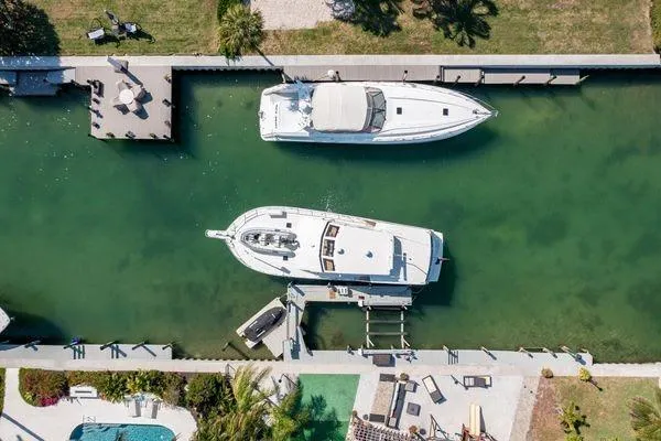 Slide: The Image of Aerial view of two yachts docked in a canal, featuring a 1993 Viking Convertible. - 15