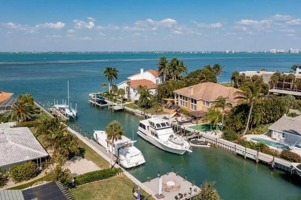 Slide: The Image of Aerial view of a 1993 Viking Convertible yacht docked in a scenic waterfront canal. - 17