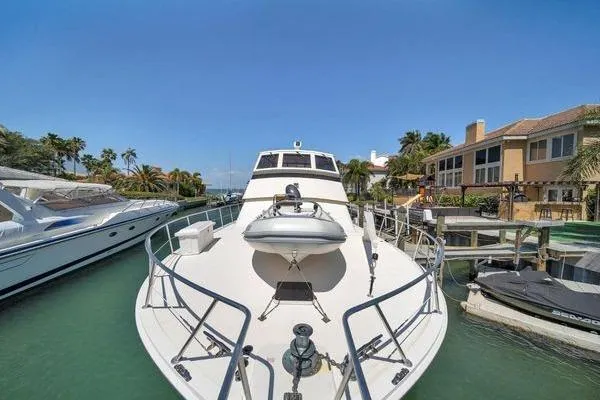 Slide: The Image of 1993 Viking Convertible yacht docked in a sunny marina, surrounded by luxury boats and waterfront homes. - 20