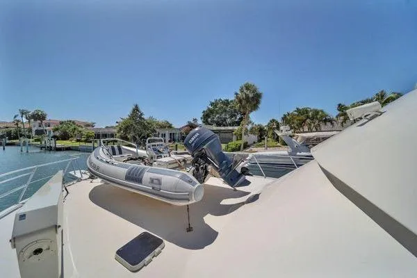Slide: The Image of 1993 Viking Convertible yacht with inflatable boat on deck, docked near waterfront homes. - 24