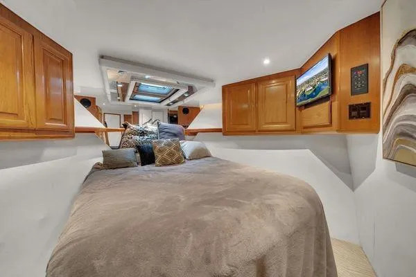 Slide: The Image of Cozy bedroom in a 1993 Viking Convertible yacht with wooden cabinets and modern decor. - 36