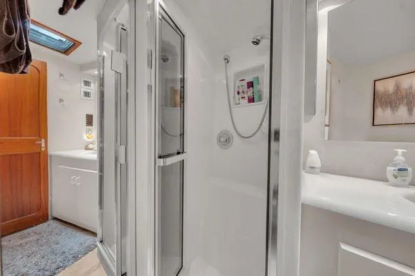 Slide: The Image of Bathroom interior of a 1993 Viking Convertible yacht, featuring a shower and sink area. - 38
