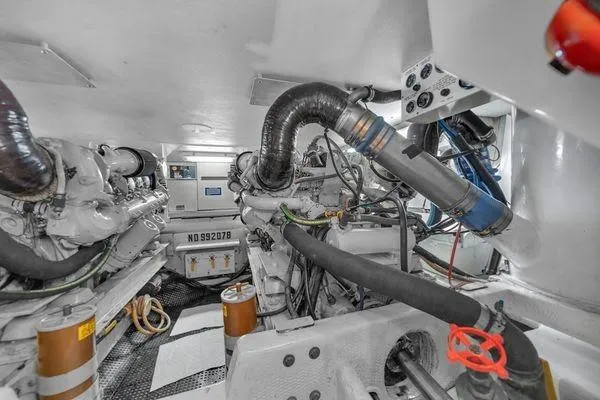 Slide: The Image of Engine room of a 1993 Viking Convertible yacht, showcasing mechanical components and piping. - 56