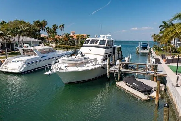 Slide: The Image of 1993 Viking Convertible yacht docked in a scenic marina with palm trees and clear skies. - 6