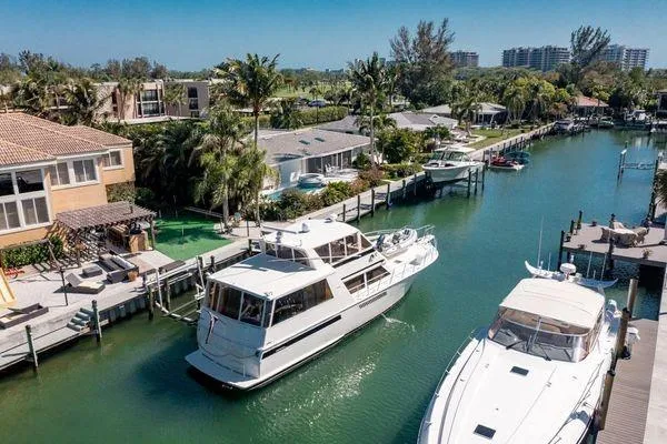 Slide: The Image of 1993 Viking Convertible yacht cruising in a scenic canal with waterfront homes. - 7