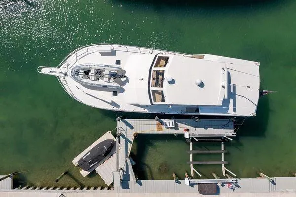 Slide: The Image of Aerial view of a 1993 Viking Convertible yacht docked in clear green water. - 9