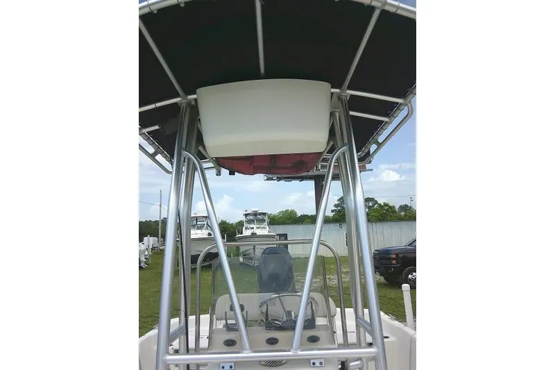 Slide: The Image of 2013 Carolina Skiff 198 DLV boat with T-top and console, parked outdoors. - 10