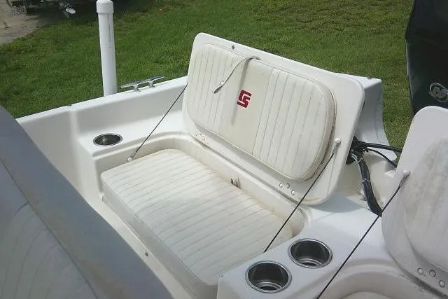 Slide: The Image of 2013 Carolina Skiff 198 DLV boat seating area with cup holders and white upholstery. - 17