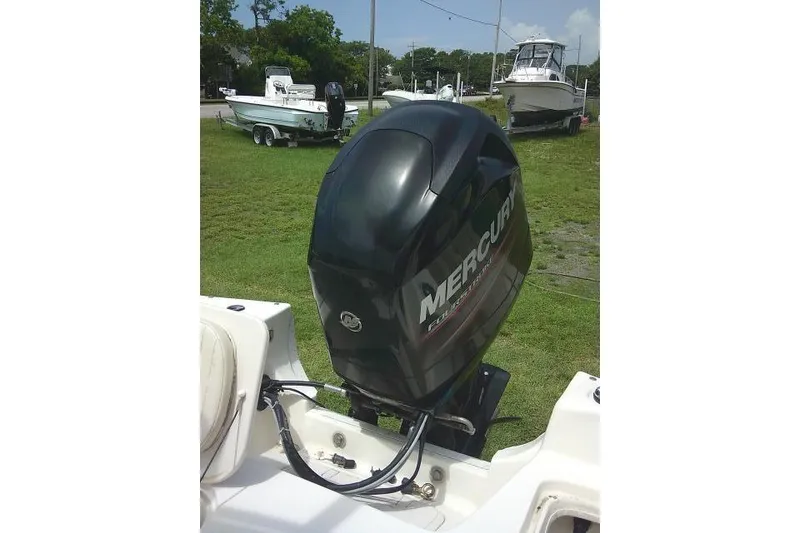 Slide: The Image of 2013 Carolina Skiff 198 DLV with Mercury outboard motor on grassy area. - 19