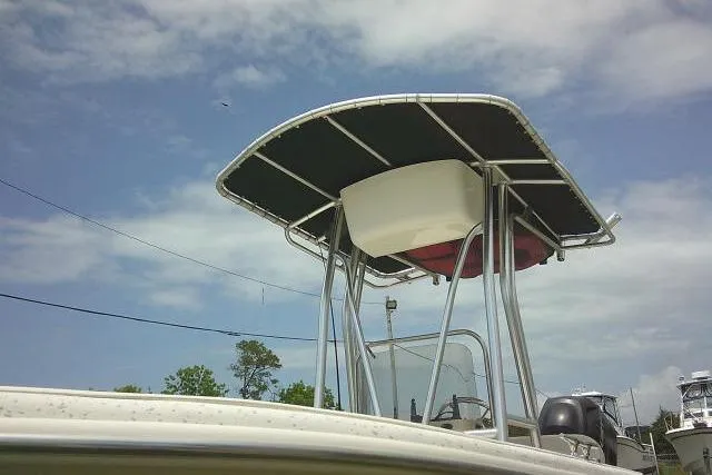 Slide: The Image of 2013 Carolina Skiff 198 DLV boat with T-top under a partly cloudy sky. - 4