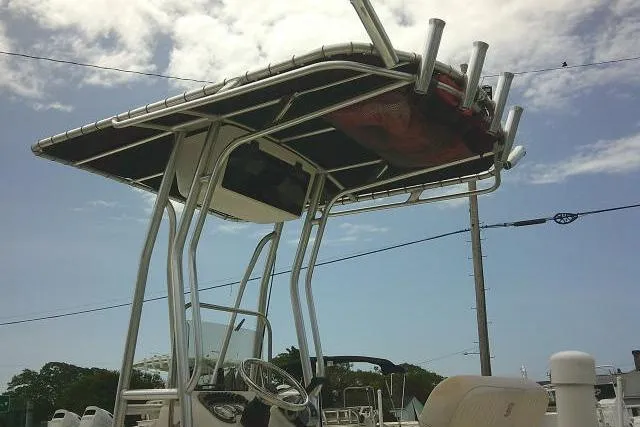Slide: The Image of 2013 Carolina Skiff 198 DLV boat with T-top under a partly cloudy sky. - 7