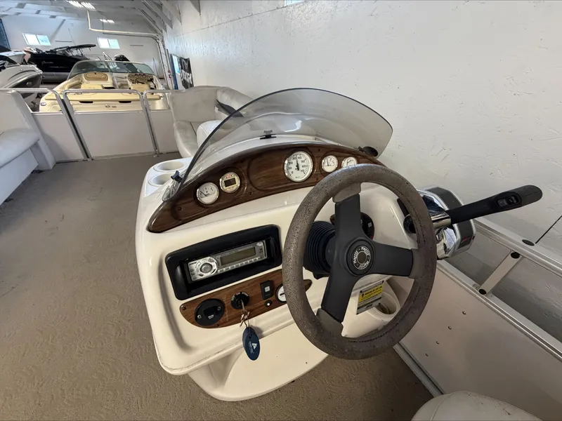 Slide: The Image of The image shows the helm of a 2007 Harris Sunliner 180 with wood trim and instruments. - 12